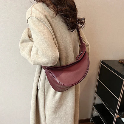 Elegant Curved Shoulder Bag with Zipper Closure and Sleek Design for Women