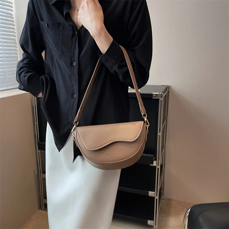 Modern Curved Leather Satchel with Sleek Design and Adjustable Shoulder Strap